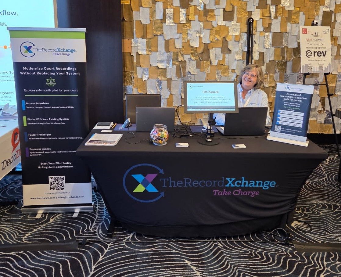 TheRecordXchange exhibit table at the AAERT Unity Summit with TRX branded tablecloth and banner